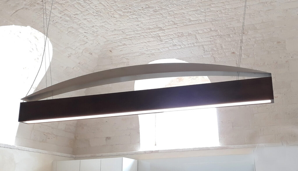 lampadario moderno in ferro battuto sotto volta in pietra di trullo